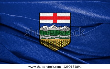 Realistic flag of Alberta on the wavy surface of fabric. Perfect for background or texture purposes
