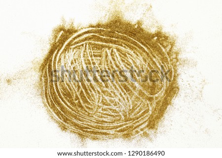 Closeup of golden glitter dust spread on white paper background
