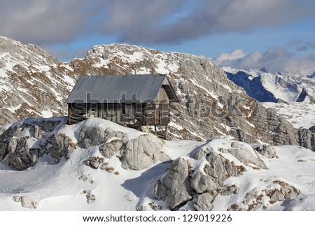 Old wooden hut in the mountains covered with snow