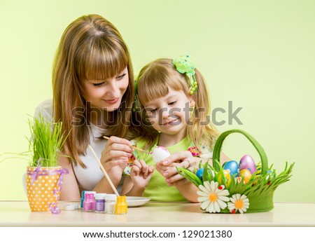 mother and kid girl paint easter eggs