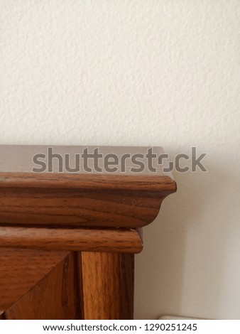 Wooden brown corner furniture on white wall background Royalty-Free Stock Photo #1290251245