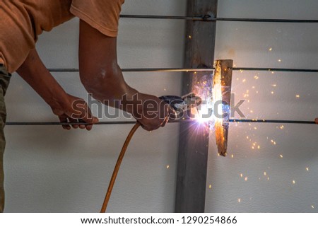 Worker welding steel bars for use as structures.
