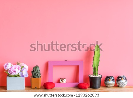 Valentine  concept  setting  with  cactus,red  heart,rose   and  simulated  owl  on  wooden  surface  with  pink  background