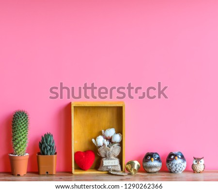 Valentine  concept  setting  with  cactus,red  heart,rose and  simulated  owl  on  wooden  surface  with  pink  background
