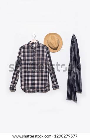 White and blue color long sleeve plaid shirt on hanging with hat and scarf isolated
