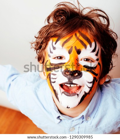 little cute boy with faceart on birthday party close up, little cute tiger