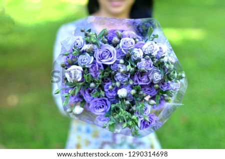 Blur image of in love girl in blue dress show purple rose bouquet, valentine day gift, love confessions by give flowers with happy feeling