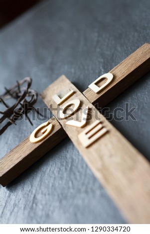 Easter christian wooden cross with an inscription god is love abstract religion background
