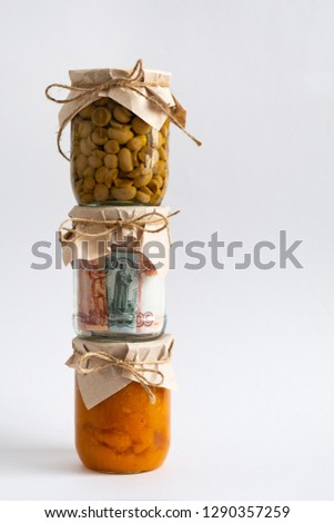 Save money concept. Homemade Pickled Vegetables in Jars. Russian rubles in glass jar.