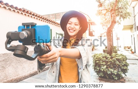 Happy asian woman vlogging with gimbal tripod and smartphone - Influencer chinese girl having fun with new trend technology - Millennial generation activity job, youth and tech concept - Focus on face Royalty-Free Stock Photo #1290378877