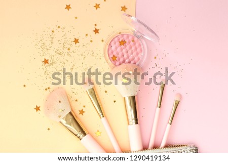 Set of makeup brushes on pink background. Top view, flat lay.