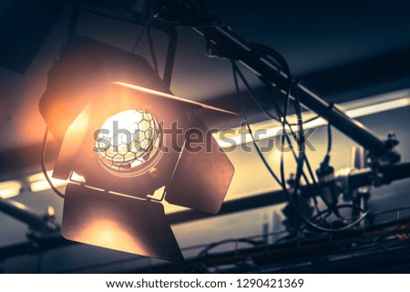 Professional orange studio spotlight hanging on the ceiling.