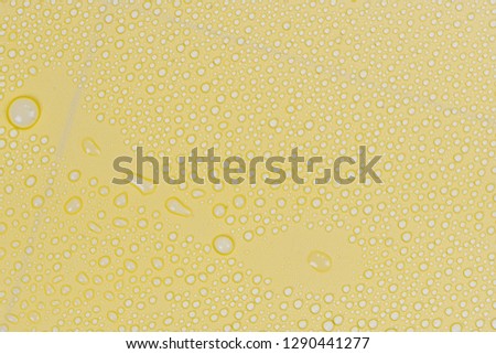 Close up of water drops on yellow tone background. Abstract orange wet texture with bubbles on plastic PVC surface or grunge. Realistic pure water droplets condensed. Detail of canvas leather texture