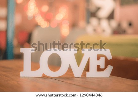 The word "Love" on wooden table with bokeh background. Vintage tone 