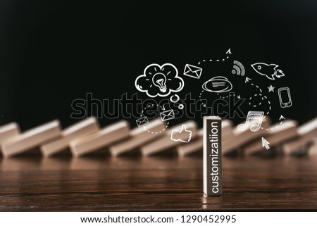 selective focus of wooden brick with word 'customization' and icons isolated on black Royalty-Free Stock Photo #1290452995