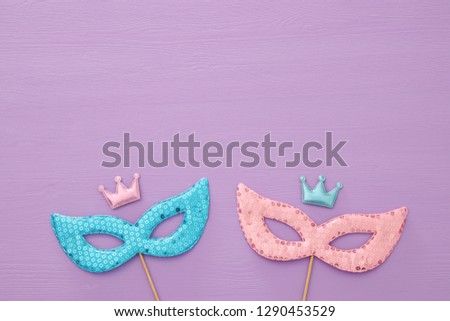carnival party celebration concept with colorful masks over purple wooden background. Top view. Flat lay