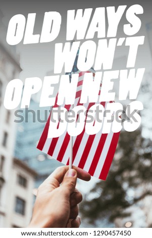 cropped shot of man holding american flag in hand with blurred new york city street on background and "old ways wont open new doors" quote