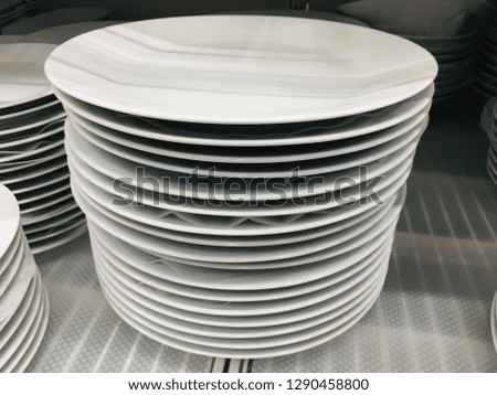 A stack of white plates in the cabinet