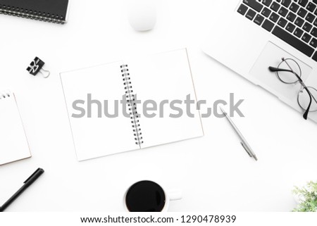 White office desk table with two blank pages of notebook with supplies. Top view with copy space, flat lay.