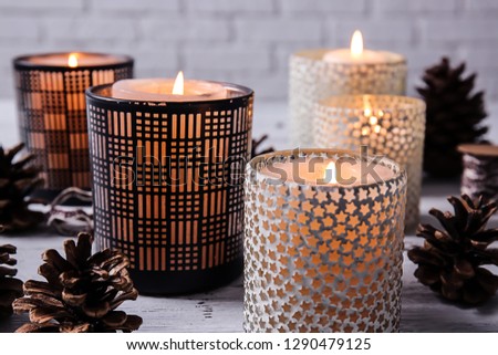Burning candles in holders on table