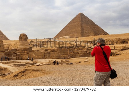 Young man taking a photos of the pyramids of Giza in Cairo Egypt