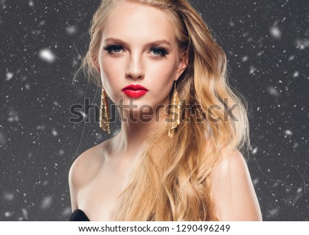 Beautiful woman blonde hair red lips winter background snow