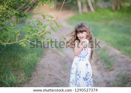 Happy and pretty little girl in spring forest.