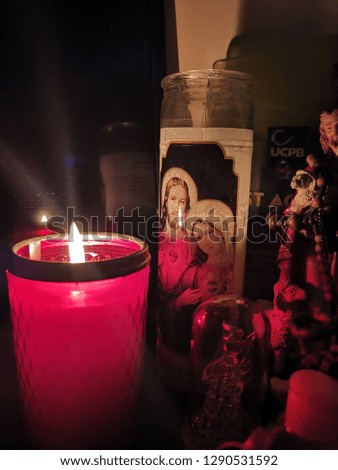 A lit candle on an altar typically found in the homes of Catholic Filipinos. 