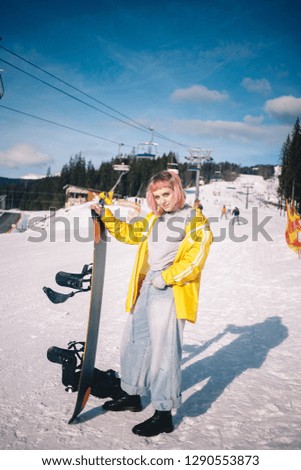 young european girl with pink hair on a snowboard