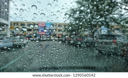 Rain drops in the car window with building in the background. 