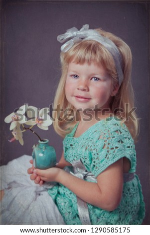 Studio photo of beautiful little girl with long blond hair.