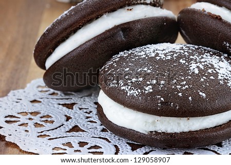 Macro image of three whoopie pies or moon pies with powdered sugar. Shallow depth of field.