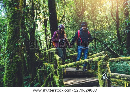 Couples traveling, relax in winter. walking travel to study nature in the rainforest. at the angka, Chiangmai in Thailand.