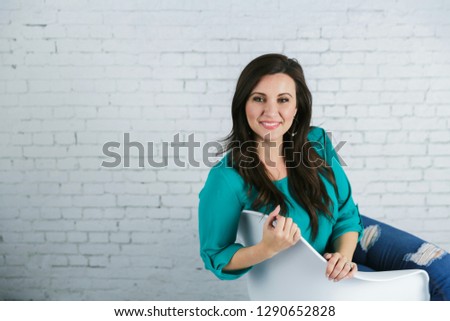 Woman Holding Blank Letter Board Sign Against White Brick Wall