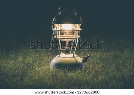 Old lantern On the lawn at night.Vintage colors picture.