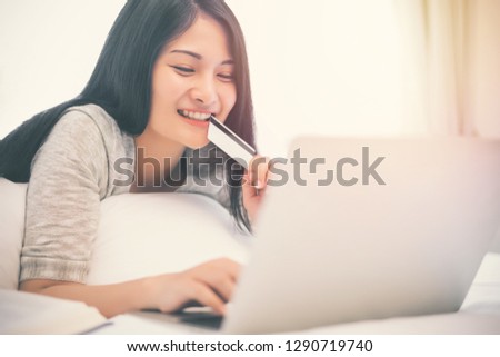 Young woman working on a laptop and uses credit card, bussiness and shopping concept.