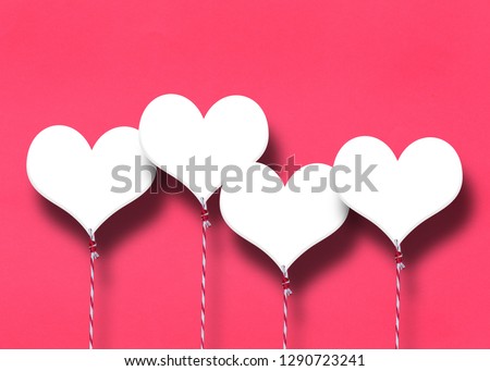 White hearts on a red paper background for the concept of love and Valentine's Day.