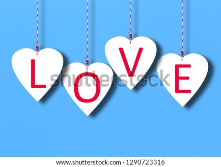 White hearts on a blue paper background for the concept of love and Valentine's Day.