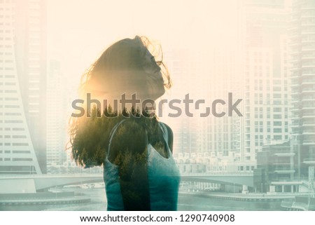 Double exposure with young woman in the modern cityscape and forest. Escape from the city concept. 