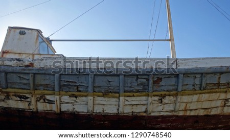                 A beautiful weather beaten, sun bleached old wooden fishing boat, pictured in Crete, Greece               