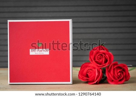 Close up red roses and heart-shaped box on wood background,Valentines Day concept with roses and red heart-shaped box