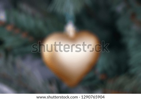 Blurred Yellow golden heart hanging on christmas tree - for valentine day patterns
