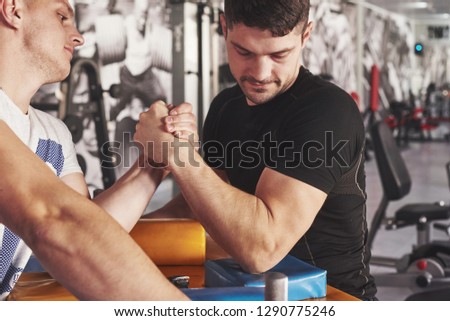 Arm wrestling challenge between two men. Match on a special table.
