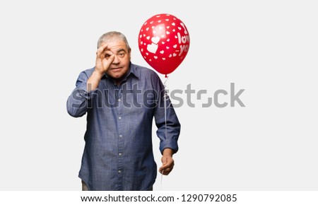 Middle aged man celebrating valentines day confident doing ok gesture on eye