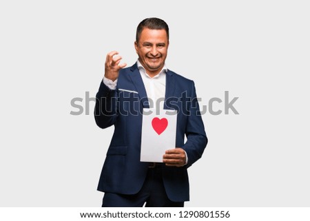 Middle aged latin man celebrating valentines day angry and upset