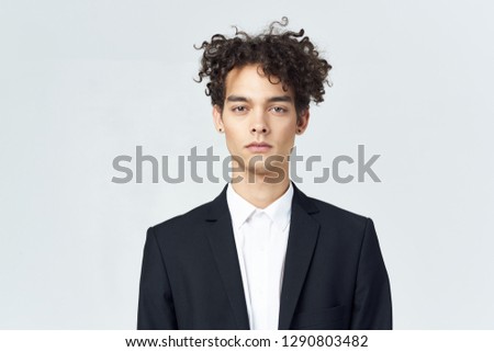 Curly young businessman looking into the camera                  