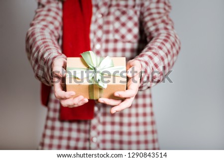 handsome man with a gift box, with long hair, isolated closeup