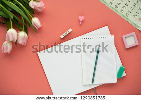 Woman's desktop with calendar, black pencil, pencil and tulips. - planning women's day. Top view