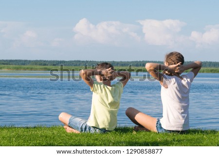 boy and girl relaxing by the lake at the weekend