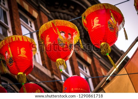 Three red chinese new year lanterns with building in background stylised photo, chinese text says "wishing you good wealth and good fortune in the new year"